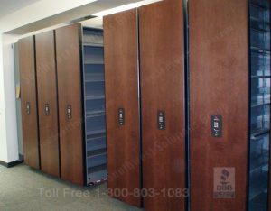 Compact rolling record storage systems use vertical open filing shelves to maximize floor space
